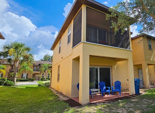 back of house with a yard and a patio