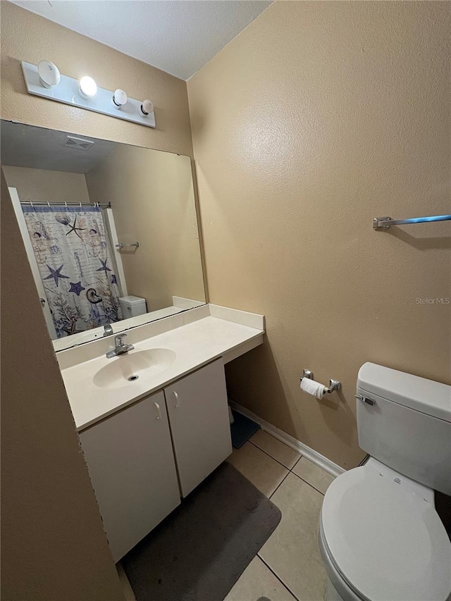 bathroom with tile patterned flooring, vanity, and toilet