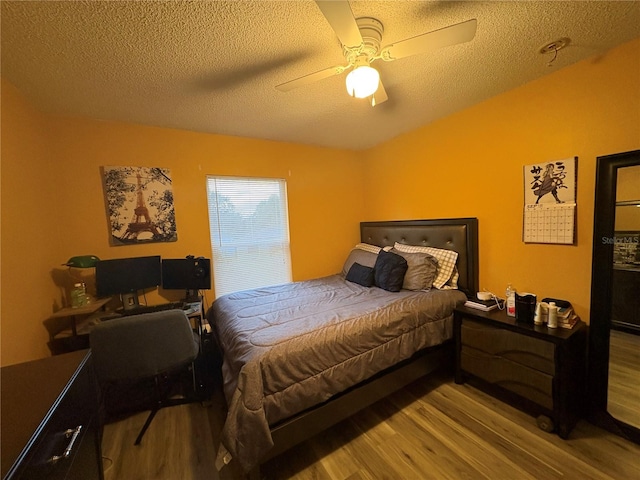 bedroom with ceiling fan, light hardwood / wood-style floors, and a textured ceiling