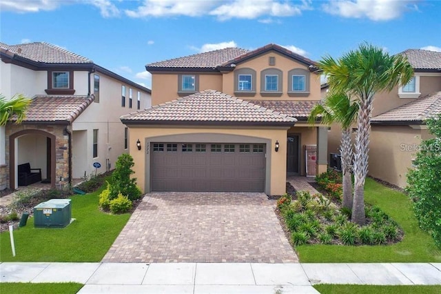 mediterranean / spanish-style home with a garage and a front lawn