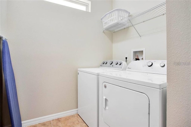 clothes washing area with light tile patterned floors and washing machine and clothes dryer