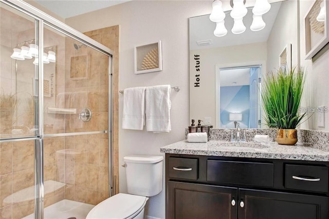 bathroom featuring vanity, toilet, and an enclosed shower