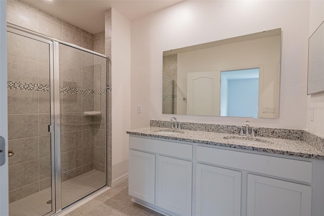 bathroom with tile patterned flooring, vanity, and a shower with door