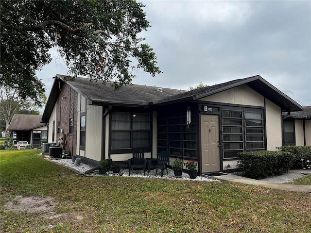 view of front of home with a front lawn and cooling unit