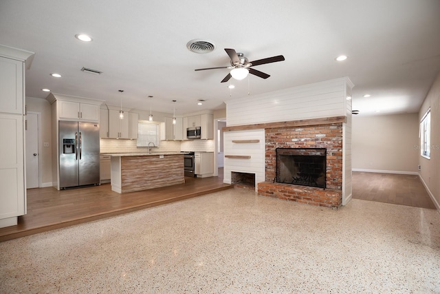 unfurnished living room featuring a brick fireplace, ceiling fan, and hardwood / wood-style floors