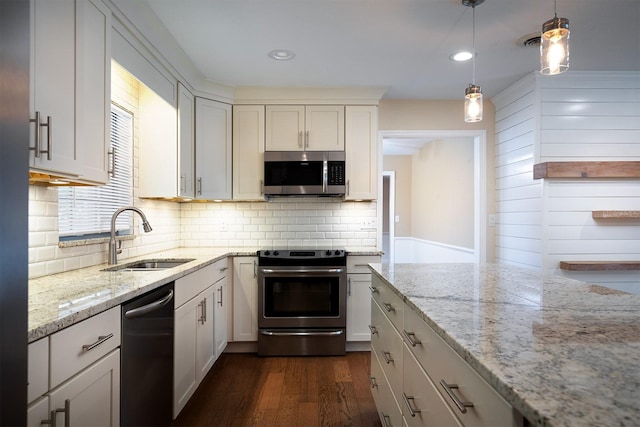 kitchen with stainless steel appliances, white cabinetry, sink, dark hardwood / wood-style floors, and decorative light fixtures