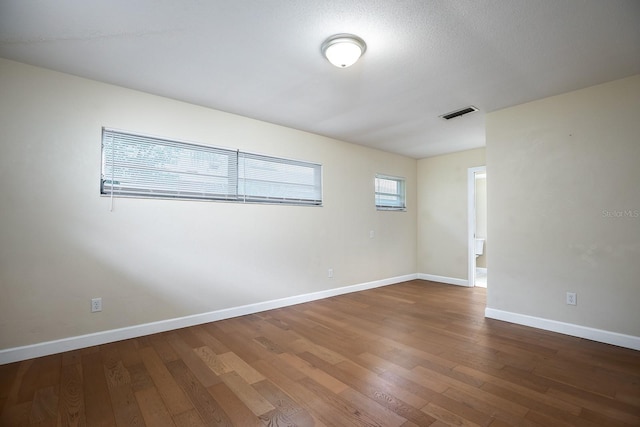 spare room with hardwood / wood-style floors and a textured ceiling