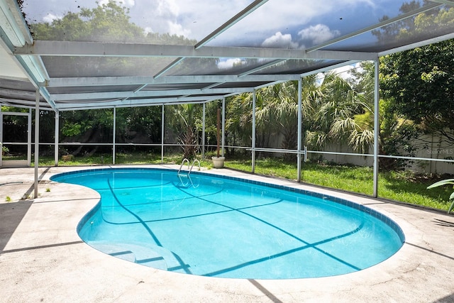 view of swimming pool featuring glass enclosure and a patio