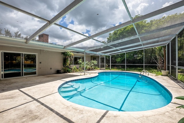 view of swimming pool featuring a patio and a lanai