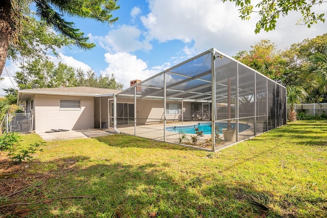 rear view of property featuring a lawn, glass enclosure, and a patio