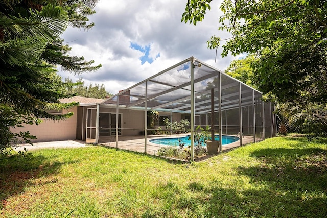 back of property featuring a lanai, a lawn, and a patio area