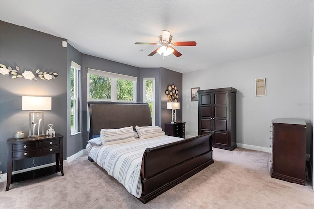 carpeted bedroom with ceiling fan and a textured ceiling