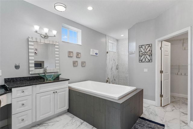 bathroom with vanity and shower with separate bathtub