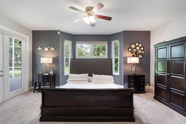 bedroom with access to outside, a textured ceiling, light colored carpet, and ceiling fan