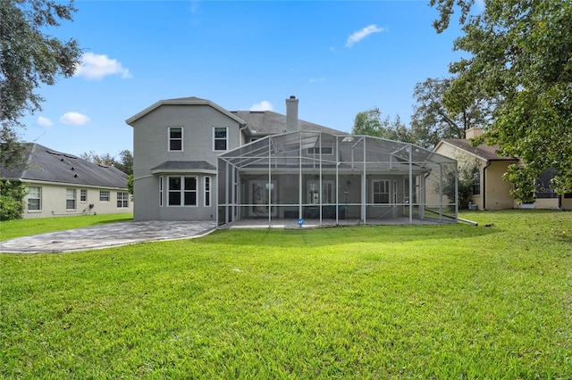 rear view of house with a lanai, a yard, and a patio