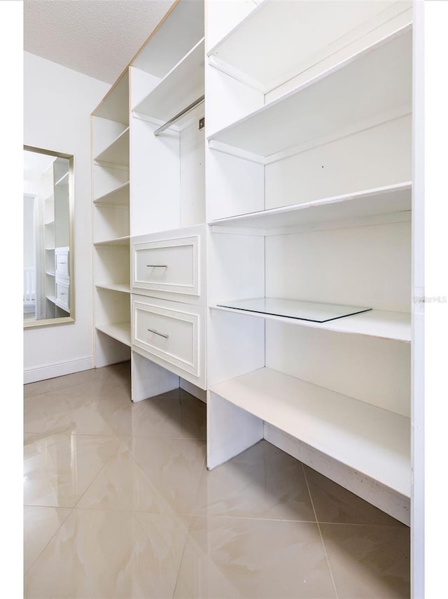 walk in closet featuring light tile patterned flooring