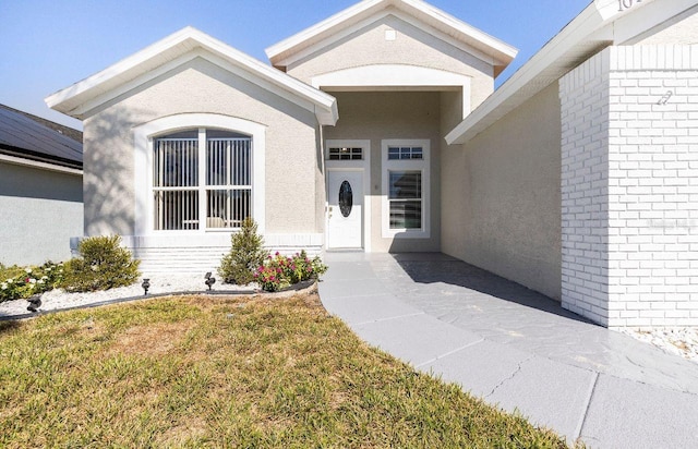 doorway to property featuring a lawn