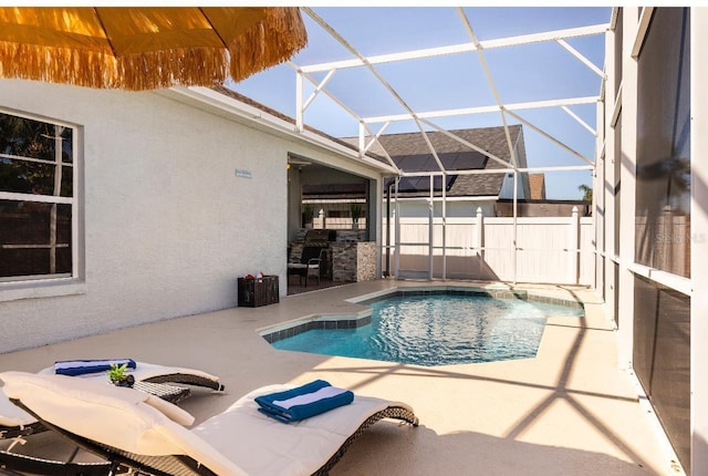 view of pool featuring glass enclosure and a patio area