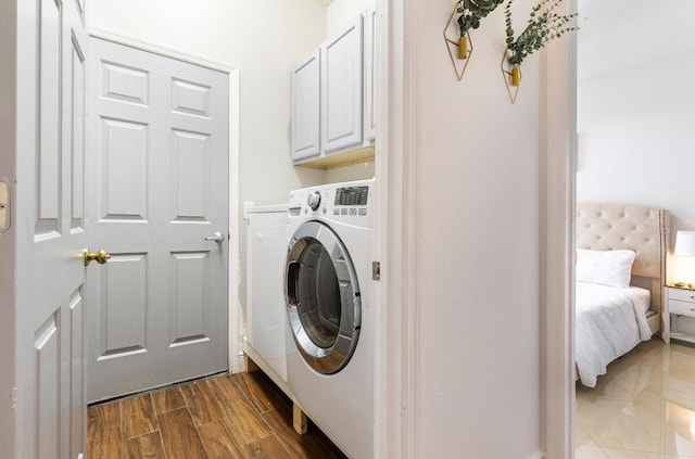 laundry area with dark wood-type flooring, washer / dryer, and cabinets