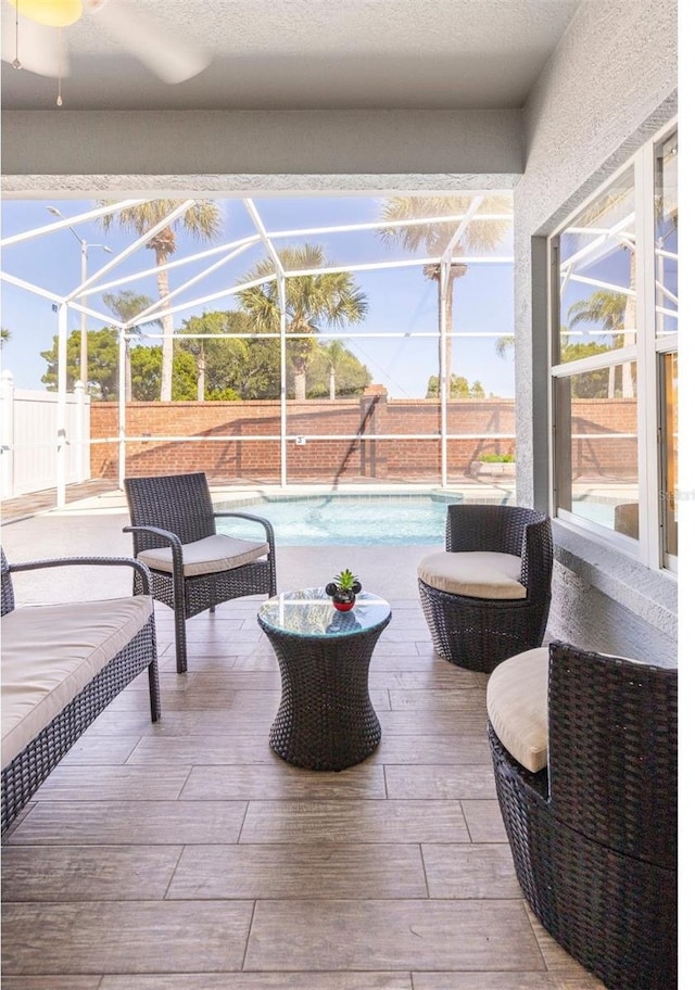 view of patio / terrace featuring a fenced in pool and glass enclosure