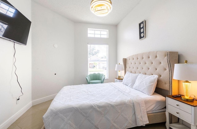 bedroom with a textured ceiling and light tile patterned floors