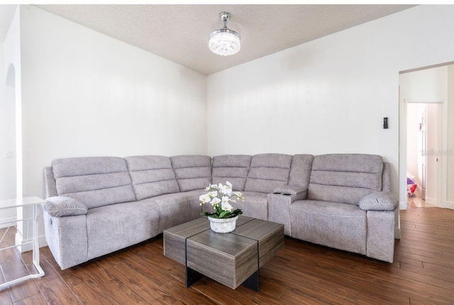 living room with dark wood-type flooring and a textured ceiling