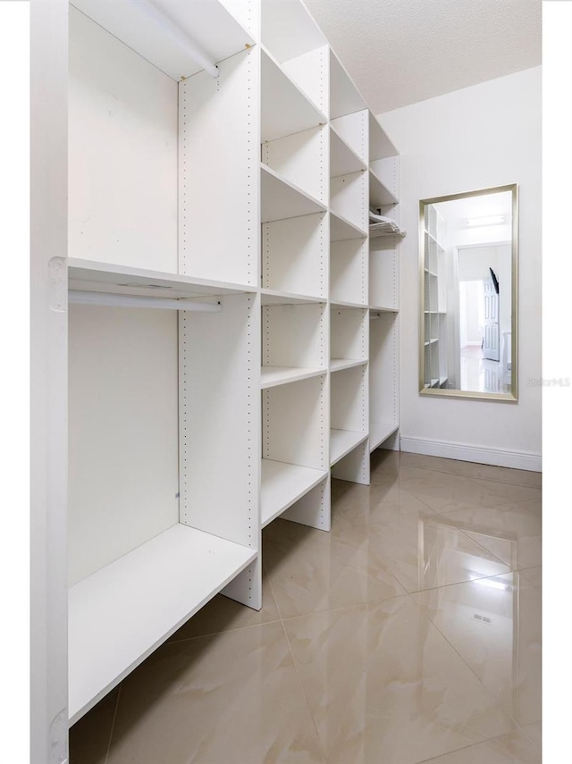 walk in closet with light tile patterned floors