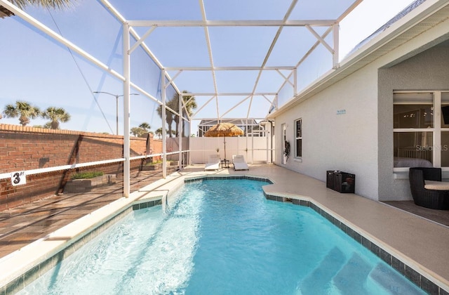 view of pool featuring glass enclosure and a patio area