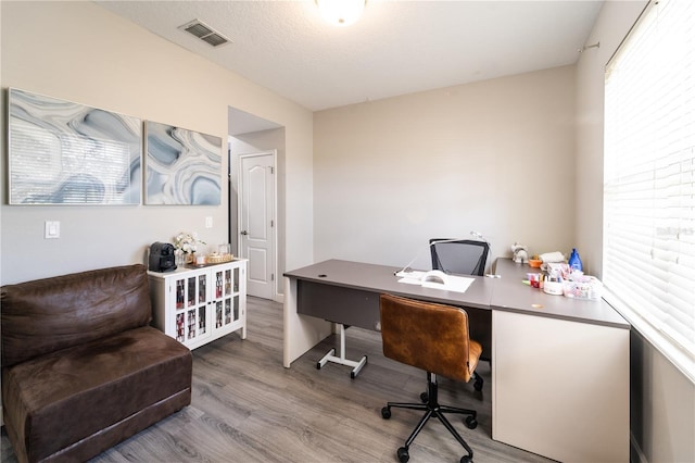 home office featuring wood-type flooring and a textured ceiling