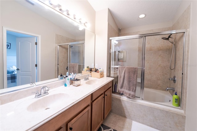 bathroom with combined bath / shower with glass door, vanity, tile patterned flooring, and a textured ceiling