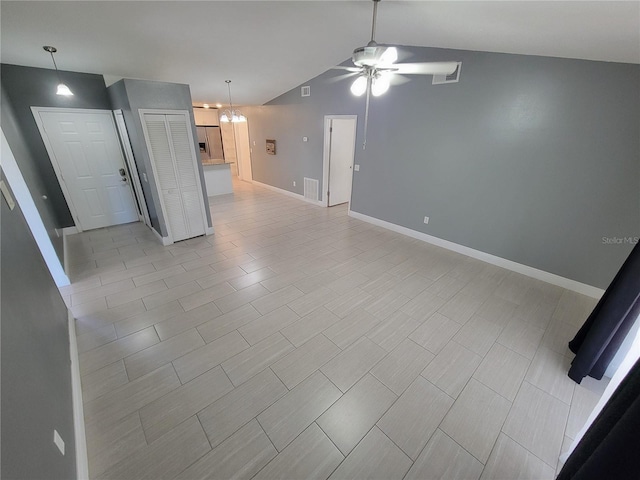 unfurnished living room featuring ceiling fan with notable chandelier and lofted ceiling