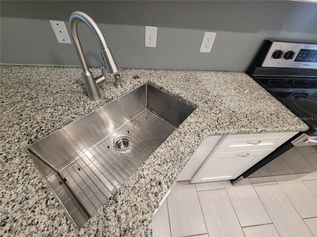 details with light stone countertops, sink, and stainless steel electric range