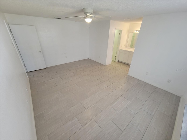 unfurnished room with a textured ceiling and ceiling fan