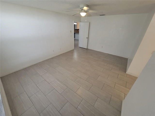 spare room featuring ceiling fan and a textured ceiling