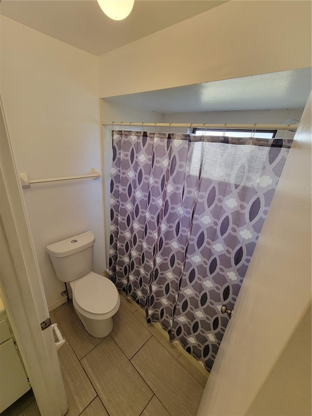 bathroom featuring toilet and walk in shower