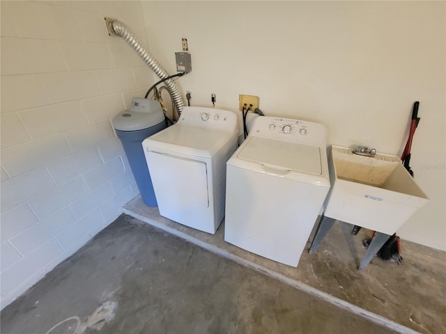 clothes washing area with sink and washer and dryer