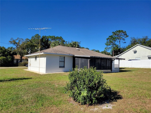 back of house with a yard and a sunroom