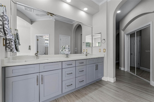 bathroom featuring ornamental molding, vanity, and hardwood / wood-style flooring