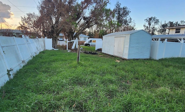 yard at dusk featuring a storage shed