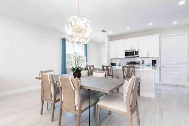 dining space with an inviting chandelier and light hardwood / wood-style floors