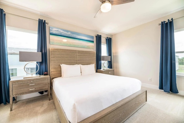 carpeted bedroom featuring multiple windows and ceiling fan