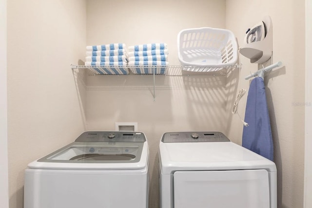 clothes washing area with separate washer and dryer