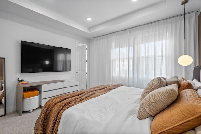 bedroom featuring a tray ceiling and light colored carpet