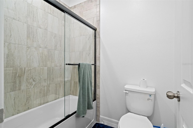 bathroom with bath / shower combo with glass door and toilet