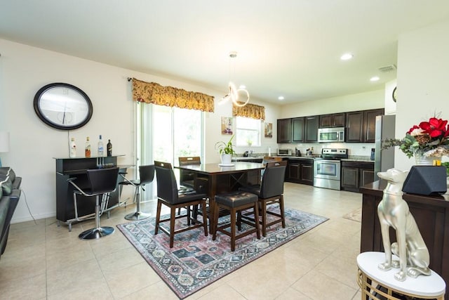 dining space with light tile patterned floors and a chandelier