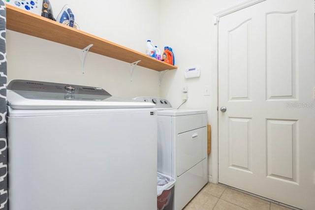 washroom with washing machine and dryer and light tile patterned floors