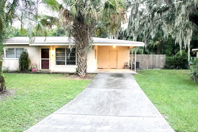 view of front of home featuring a front lawn, central AC unit, and a carport