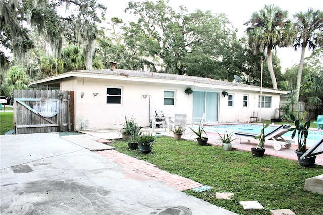 back of house featuring a patio and a fenced in pool