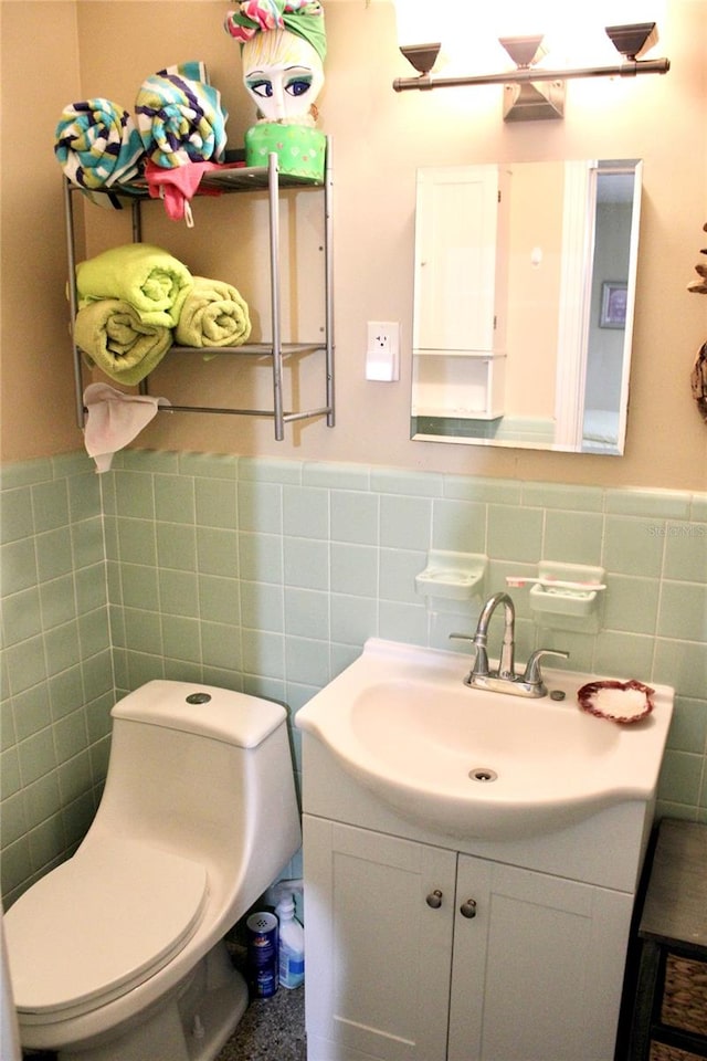 bathroom with tile walls, vanity, and toilet