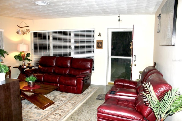 living room with a textured ceiling, visible vents, and speckled floor